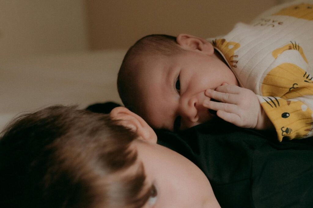 Un bébé éveillé est posé sur le dos de son grand frère