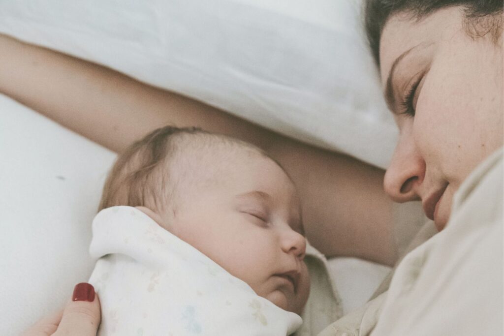Bébé dormant paisiblement dans les bras de sa mère