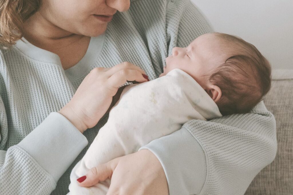 Bébé dormant paisiblement dans les bras de sa mère
