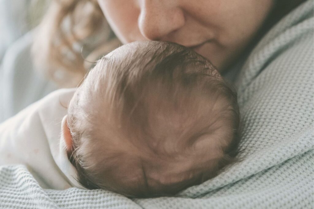 Maman qui sent la tête de son bébé