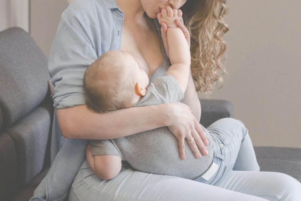 Mamn qui embrasse la main de son petit qui est allaité
