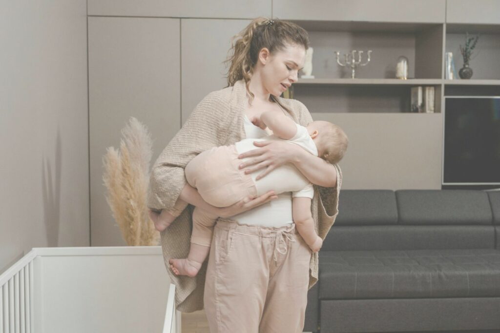 Une mère allaite son enfant debout, juste avant d'aller au lit